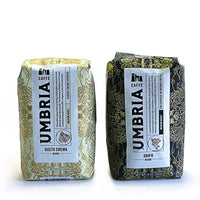 a cream bag of coffee and black bag of coffee on white background