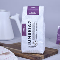 Umbria coffee bag on a wooden cutting board with a blurred background
