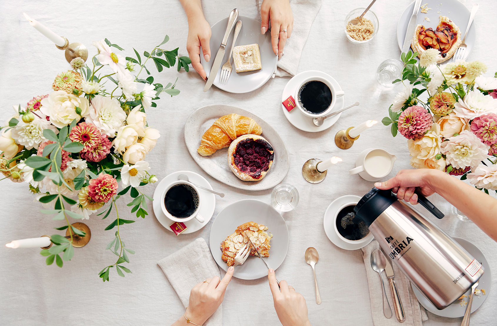Table spread with Umbria Coffee, pastries, and flowers