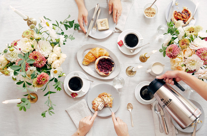 Table spread with Umbria Coffee, pastries, and flowers